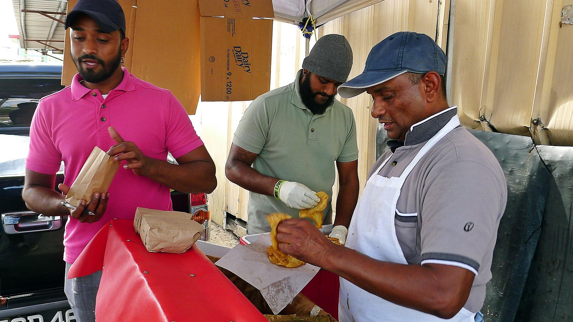 Vendeurs préparant des doubles, une cuisine de rue de Trinidad