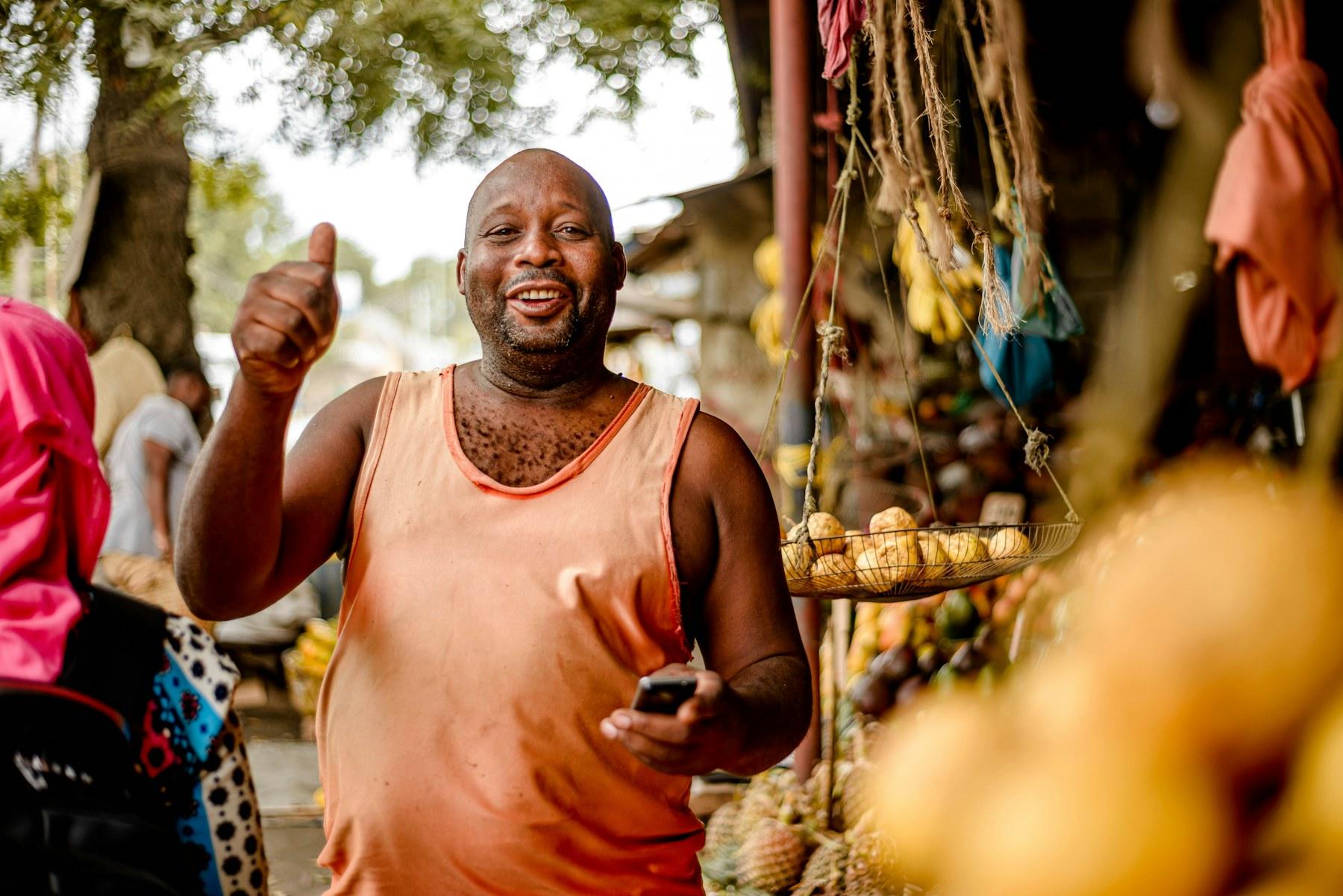Commerçant souriant au milieu d’un marché vivant